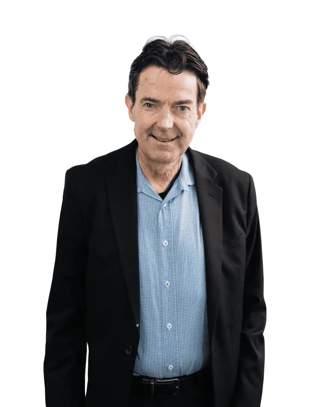 Smiling man in a black blazer and blue patterned shirt against a white background